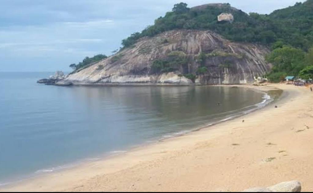 una playa de arena con una isla en el agua en Ban Khao Tao Beach, en Sathani Khao Tao