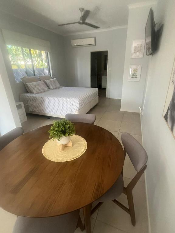 a living room with a wooden table and a bed at Reid's Retreat - Studio Apartment in Port Douglas
