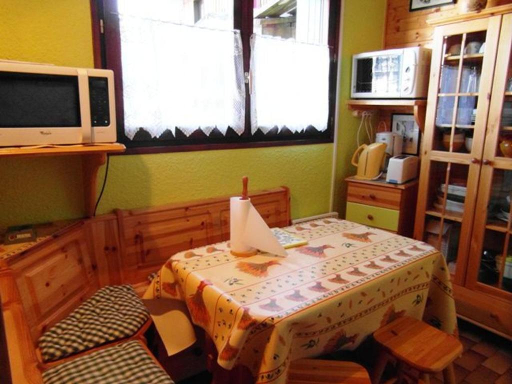 普拉茲德里斯Studio cosy centre Praz de Lys, 100m des pistes - FR-1-815-26的带桌子和电视的餐厅