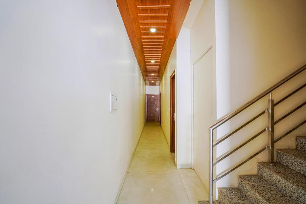 齐拉克普尔Hotel O Tree Inn的走廊设有楼梯和木制天花板
