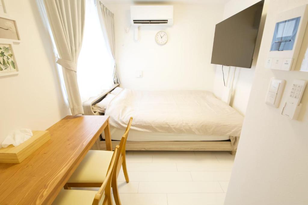 a small bedroom with a bed and a desk at オーブリオン恵比寿203 in Tokyo