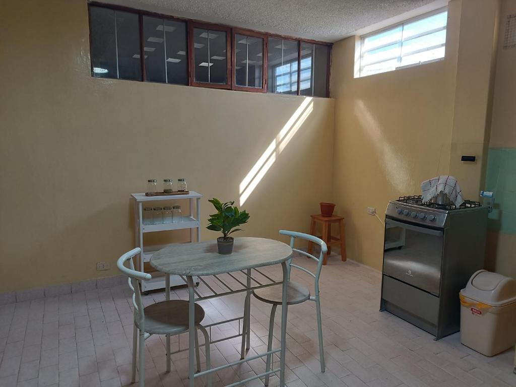 y cocina con mesa, sillas y fogones. en Departamento amoblado en primer piso 200 MTS a tu disposición con todos los servicios, en Tacna