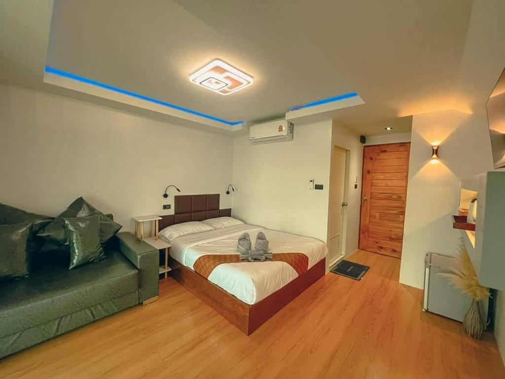 a bedroom with a bed and a couch at บ้านหัวเรือโฮมสเตย์เกาะลิบง Baan huaruea homestay in Ko Libong