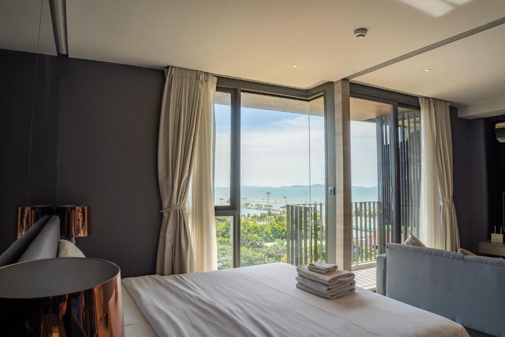 a bedroom with a bed and a large window at Seaphere Residence by Prop Hopper in Na Jomtien