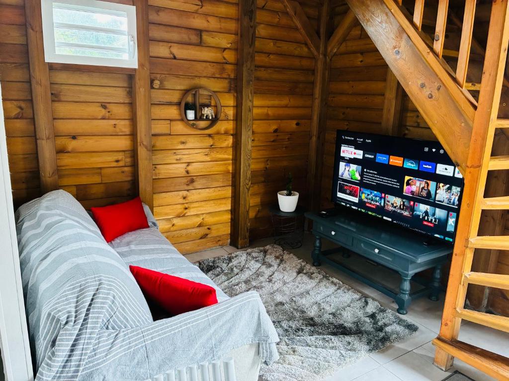 een woonkamer met een bank en een flatscreen-tv bij La Palmeraie du Carbet in Capesterre-Belle-Eau