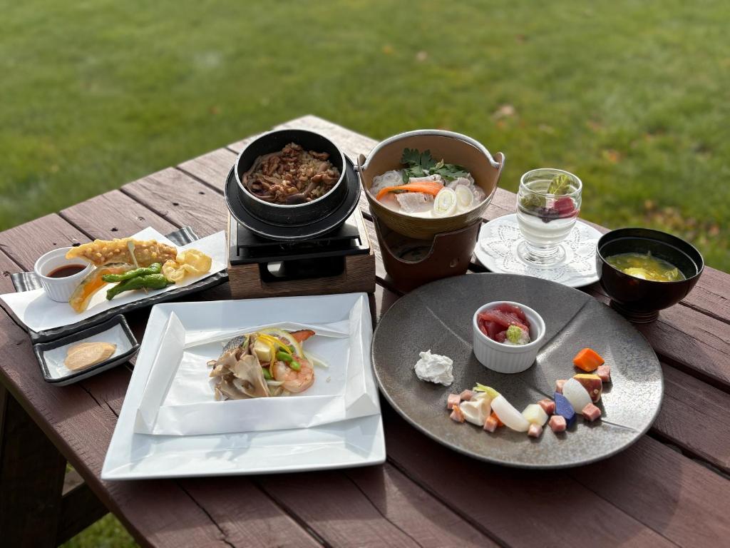 une table en bois avec des assiettes de nourriture dessus dans l'établissement Tokachi Nauman Onsen Hotel arco, à Makubetsu
