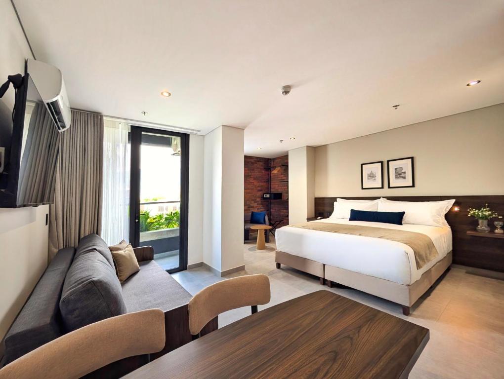 メデジンにあるLaureles Selection Suitesのベッドとソファのある寝室