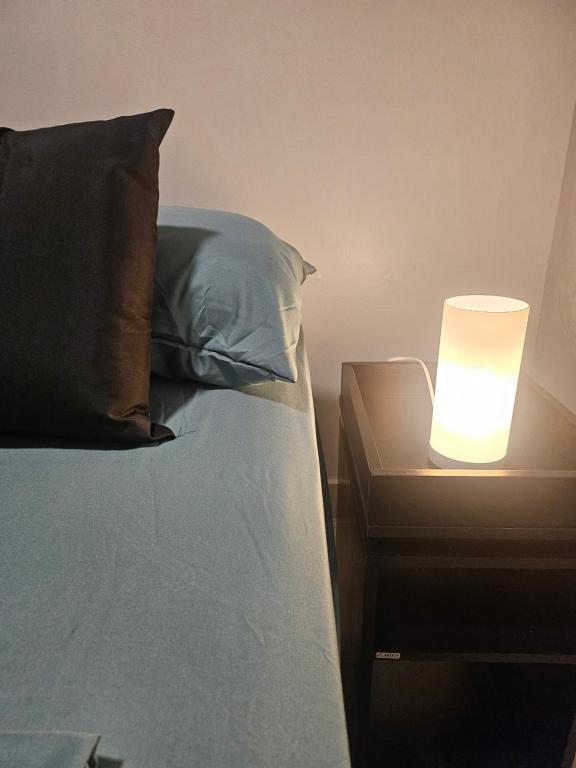 een bed met een nachtkastje met een lamp erop bij Kit Osaka in Brasilia