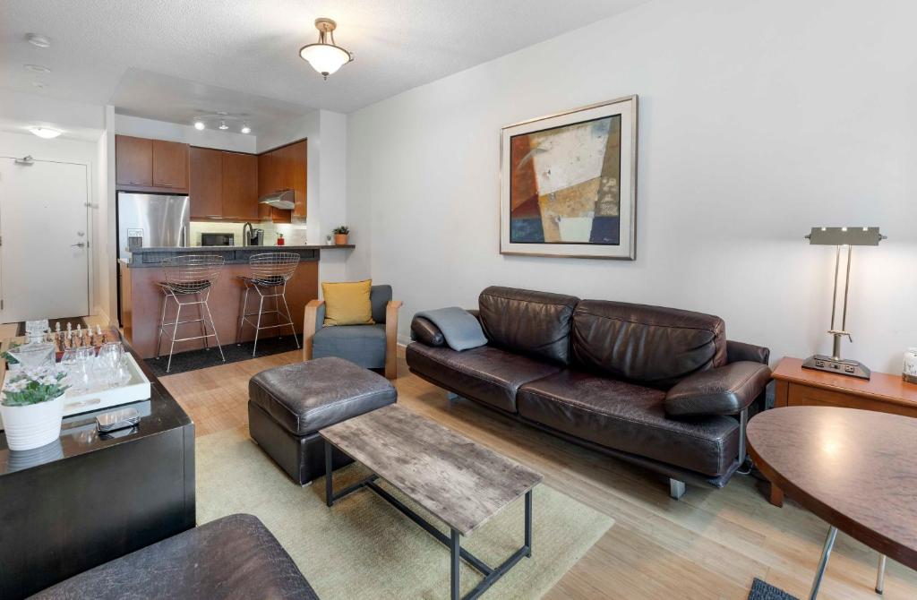 a living room with a couch and a table at Luxury 1-Bedroom Condo in Yorkville, Downtown Toronto in Toronto