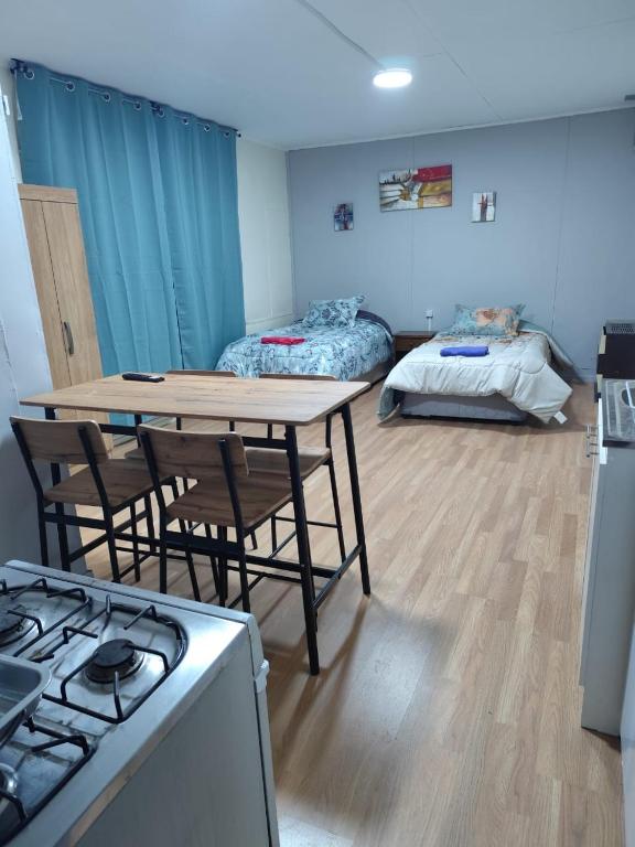纳塔列斯港Cabaña Pipe的一间带桌椅的厨房和一间卧室