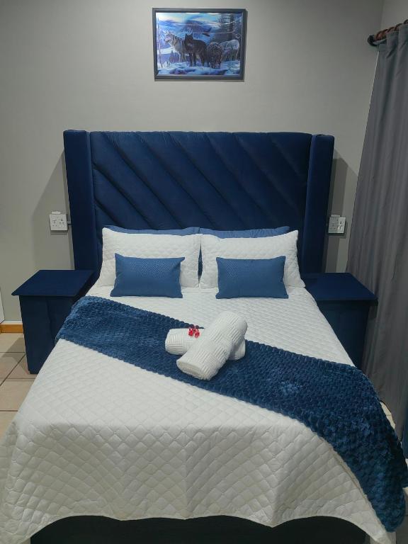 a blue and white bed with two pillows on it at WegkruiperQ in Beaufort West