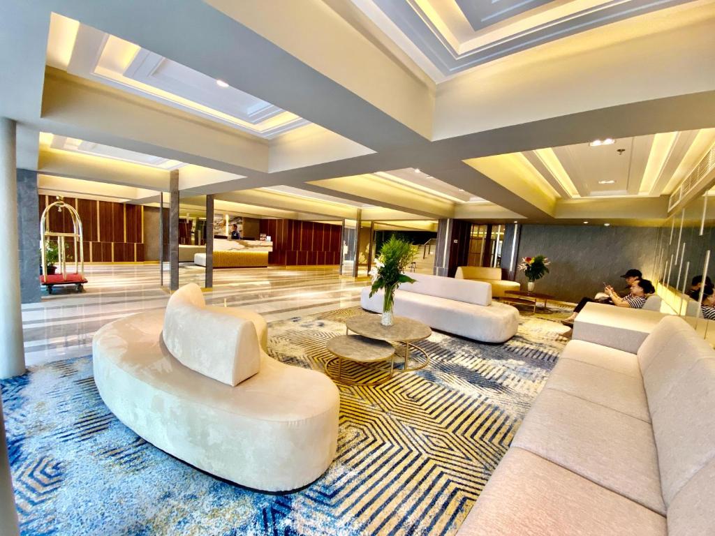 スルポンにあるAll Nite and Day Hotel Alam Suteraの白いソファとテーブルが敷かれたロビー