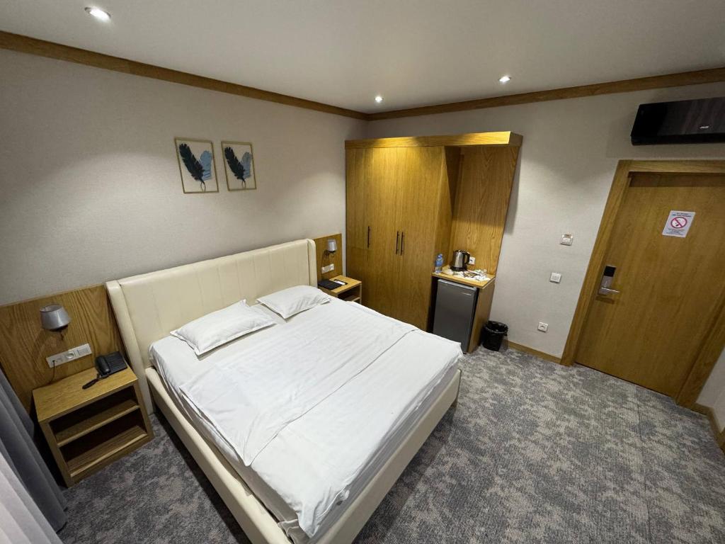 a bedroom with a large white bed in it at Muhammad in Andizhan