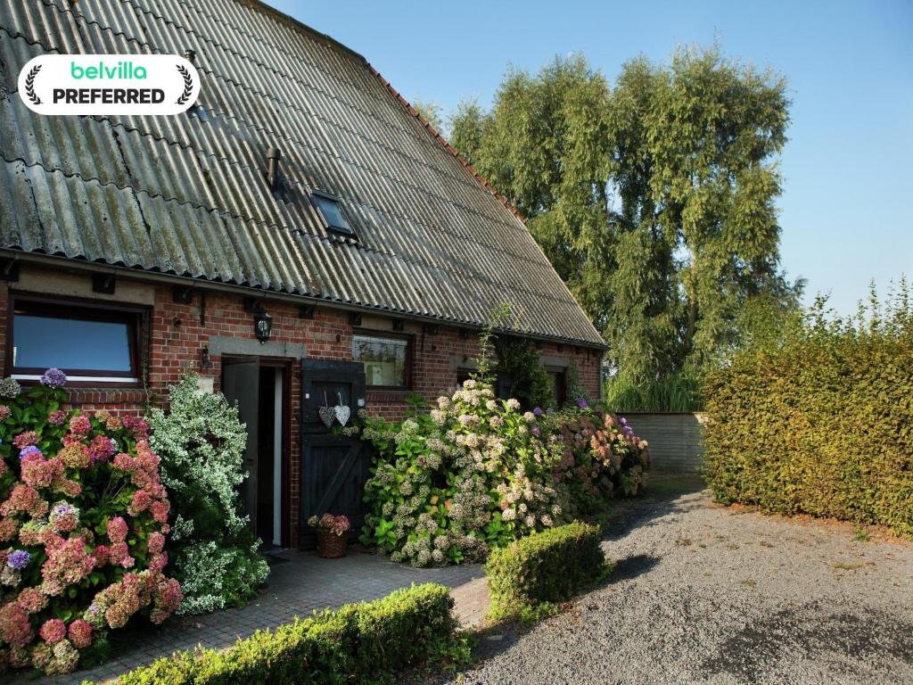 a building with a bunch of flowers in front of it at Farmhouse appartment in Eede in Eede