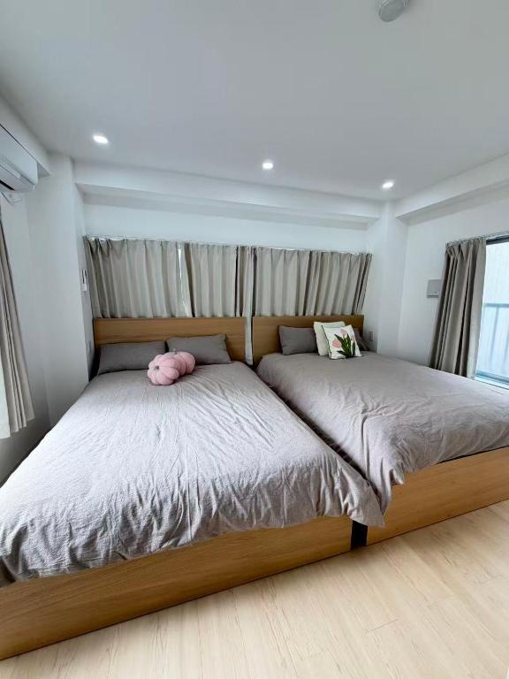 a bedroom with a bed with a pink stuffed animal on it at PUZZLE hotel 301 in Tokyo