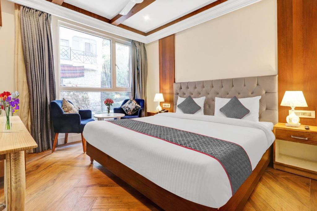 a hotel room with a large bed and a window at Hotel Aerotech Near Delhi Airport in New Delhi