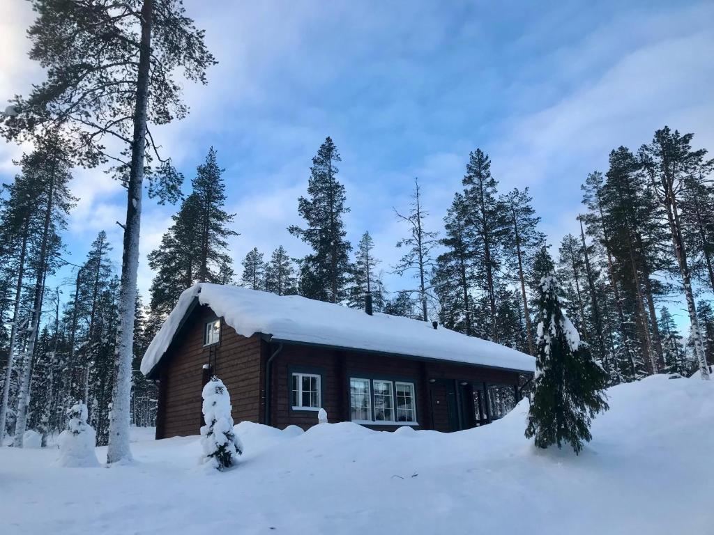 une cabane en rondins avec de la neige sur le toit dans l'établissement Ylläksen Taiga, à Ylläsjärvi