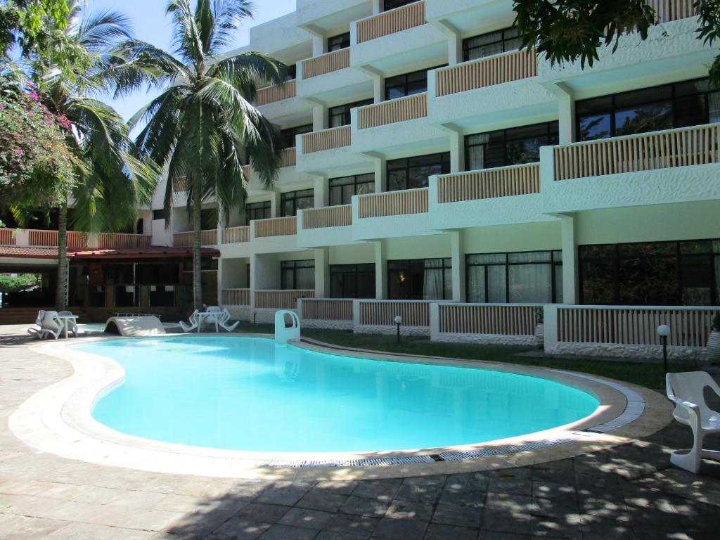 a swimming pool in front of a building at Indiana Beach Apartments in Bamburi