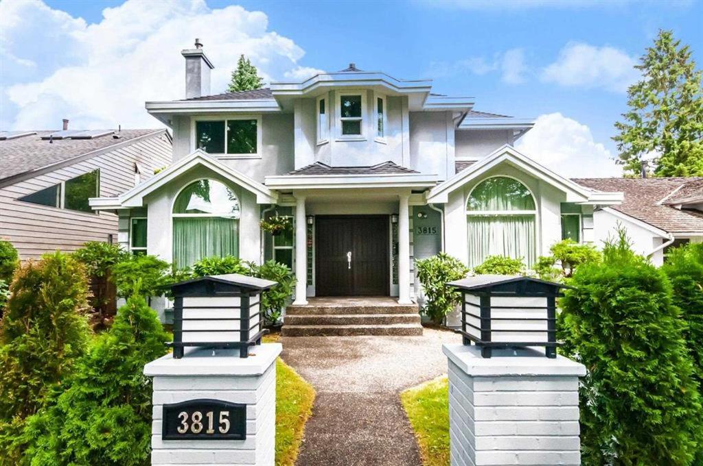 una casa blanca con dos letreros con el número delante en W 20 House, en Vancouver