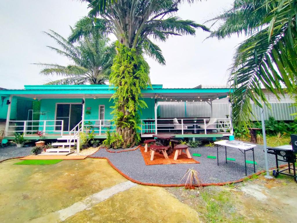 a house with a palm tree in front of it at Palm Garden house 1 close to Bang Tao beach in Ban Phak Chit