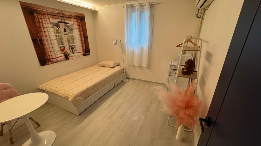 a small room with a bed and a table at SRR Stay in Gwangmyeong