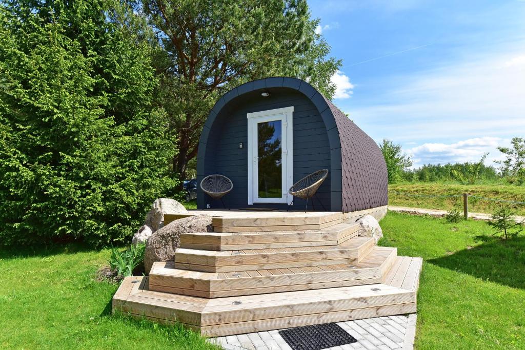 a small dome house with stairs in a yard at Mileikių sodyba namelis dviems in Šarkiškės