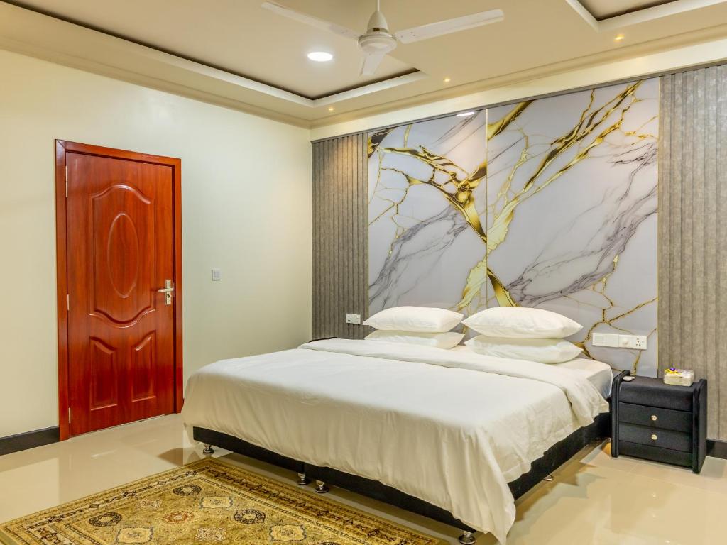 a bedroom with a bed with a painting on the wall at Villaasa in Shaviyani Atoll