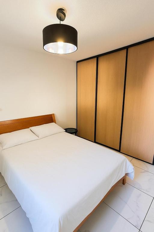 a bedroom with a white bed and a light at Appartement t3 à Montpellier in Montpellier