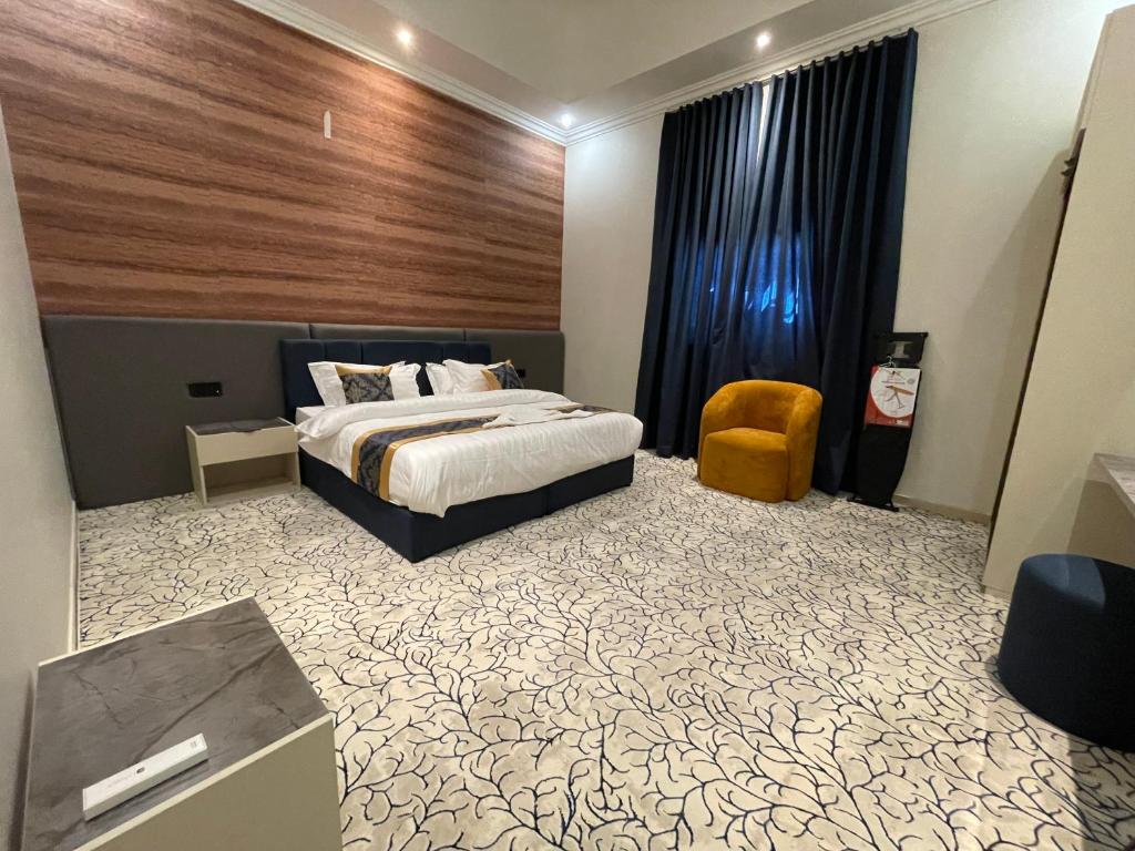 ein Schlafzimmer mit einem Bett und einem Stuhl in der Unterkunft ايفان شقق المخدومة العوالي in Quai