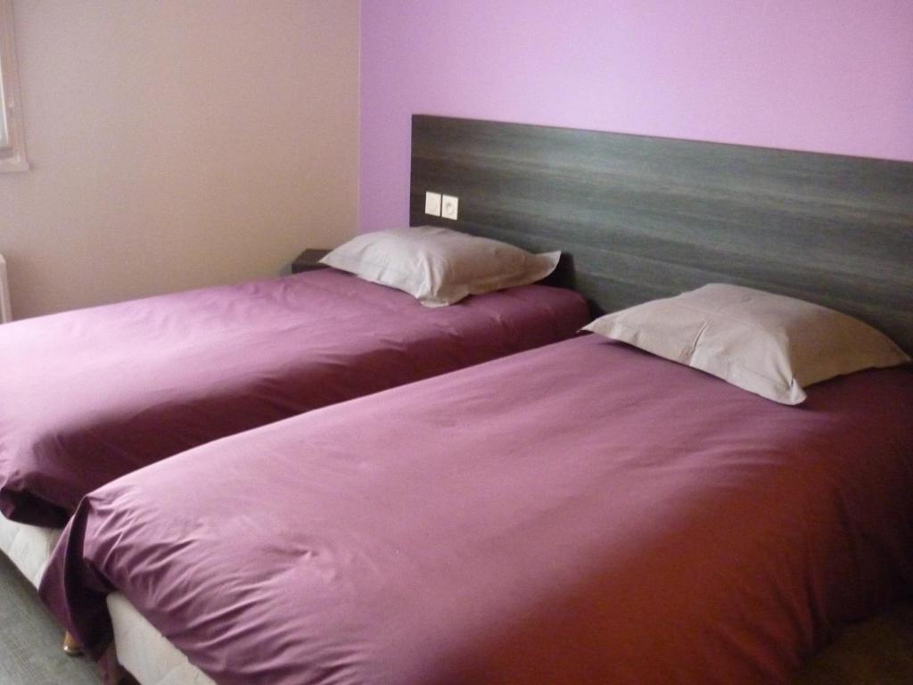 two beds sitting next to each other in a bedroom at L'envers du Castille in Parthenay