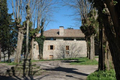 ein großes Steingebäude inmitten von Bäumen in der Unterkunft Casa Grande da Capellania in Padrón