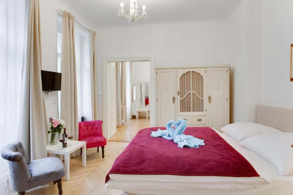 プラハにあるプラハ シエスタ アパートメントのベッドルーム1室(赤毛布付きの大型ベッド1台付)