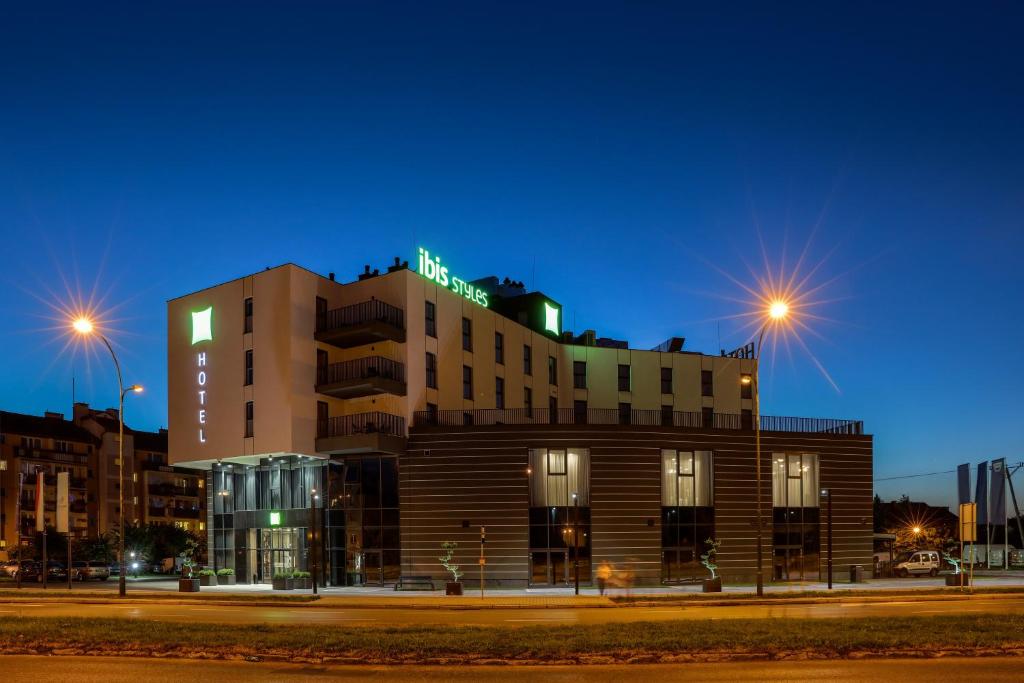 a building with a sign on top of it at night at ibis Styles Nowy Sacz in Nowy Sącz