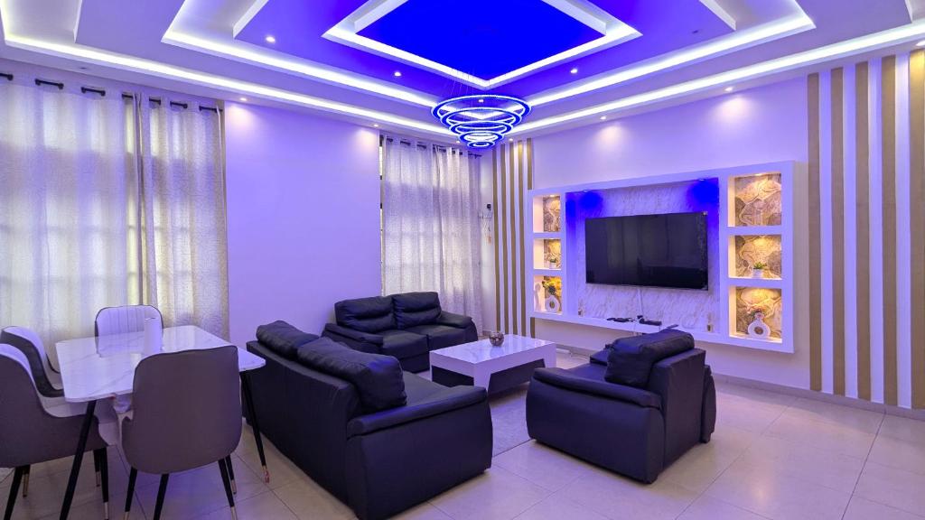 a living room with couches and a table and a tv at EZK Appart in Kika