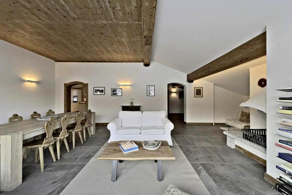 a living room with a white couch and a table at Attic Lake View with Free Parking in Silvaplana