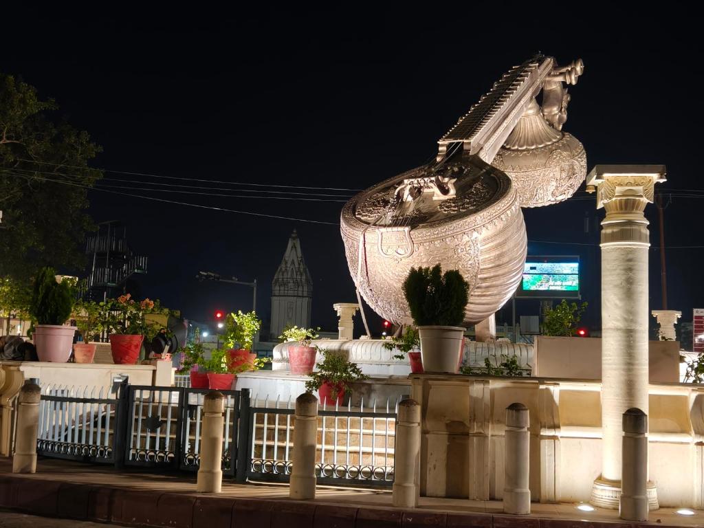 a statue of a woman sitting on top of a fence at Vaidik Vedaas Villa Ayodhya- Ram Paidi in Ayodhya