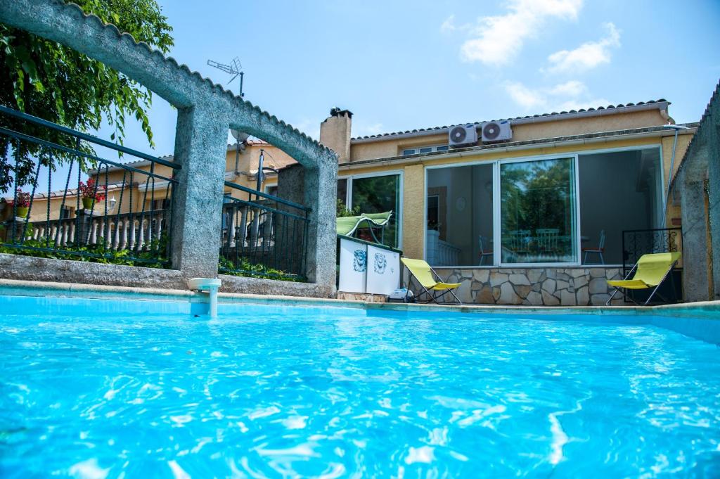 a swimming pool in front of a house at Domaine De Bailheron in Béziers