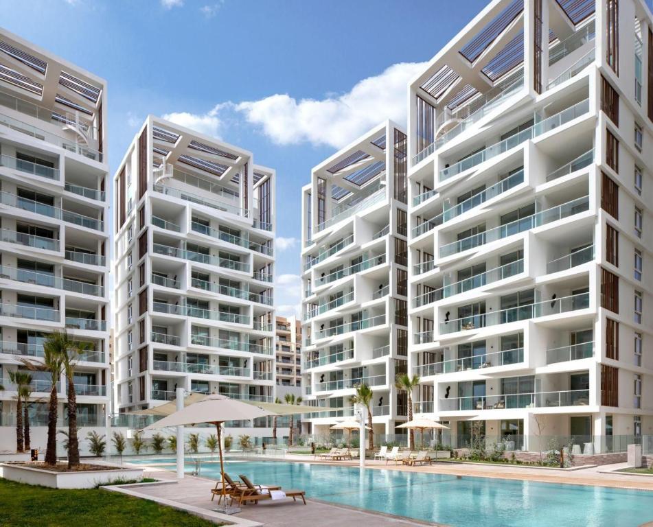 an image of two apartment buildings with a swimming pool at סוויטה משפחתית מפנקת בראון 42 אילת in Eilat
