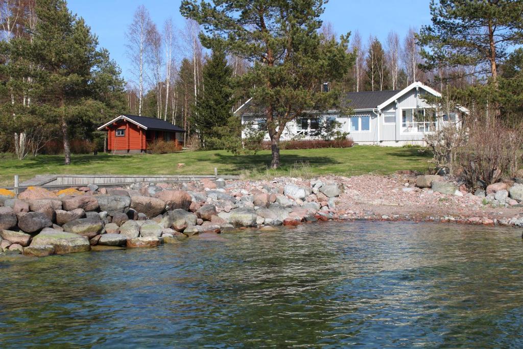 una casa con una cabaña roja junto a un río en Villa Solstrand en Fagerlund