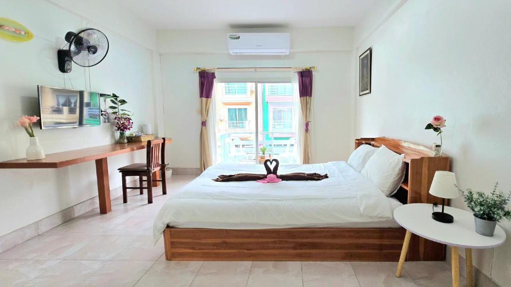 a bedroom with a bed and a desk at You And Me Guesthouse in Cha Am