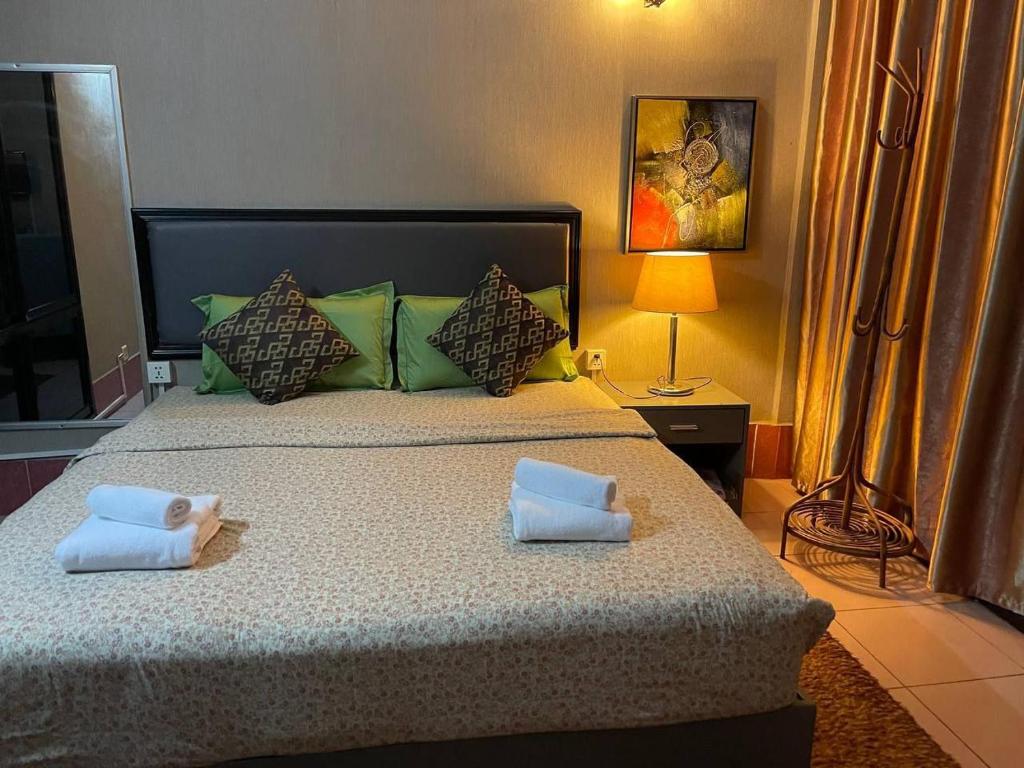 una camera da letto con un letto grande con due cuscini di Pickyard Guest House a Phumĭ Prêk Chrey