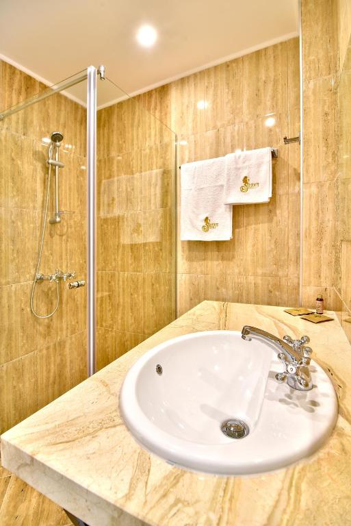 a bathroom with a sink and a shower at Sirena Palace Family Hotel in Obzor