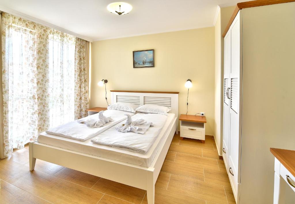a bedroom with a large white bed in a room at Sirena Palace Family Hotel in Obzor