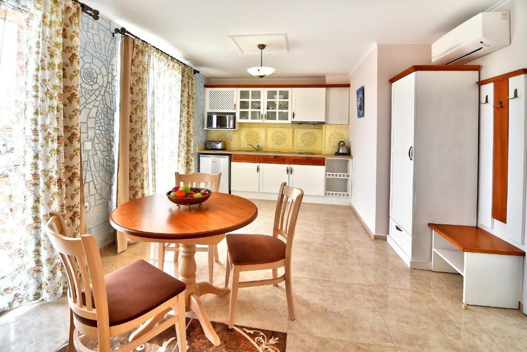 a kitchen and dining room with a table and chairs at Sirena Palace Family Hotel in Obzor