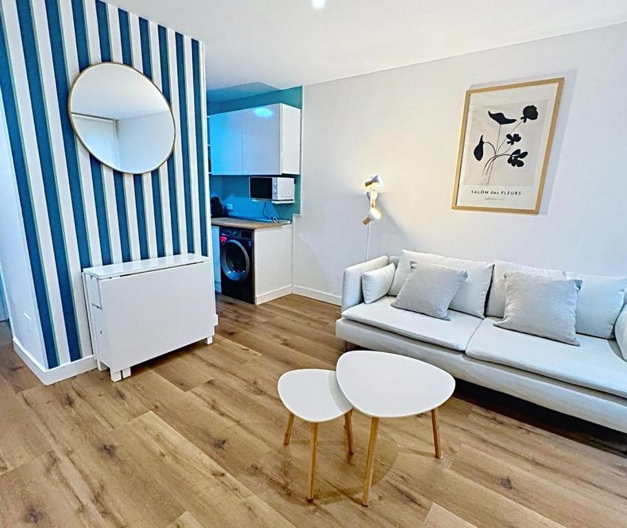 ein Wohnzimmer mit einem Sofa, einem Tisch und einem Spiegel in der Unterkunft Bajo reformado con terraza en Mogro in Mogro