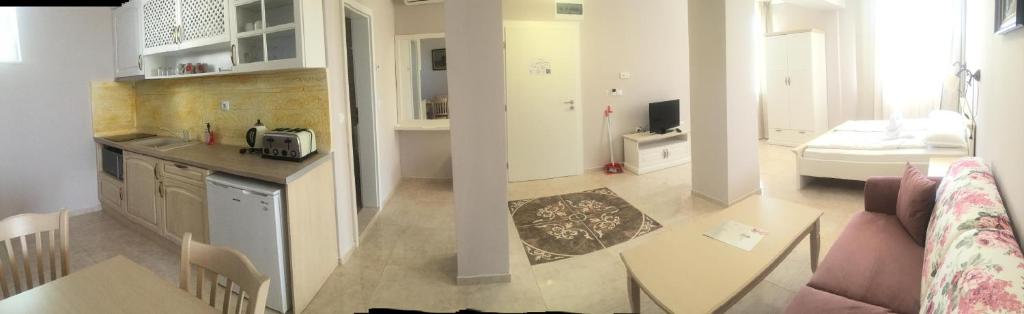 a kitchen and a living room with a couch and a table at Sirena Palace Family Hotel in Obzor