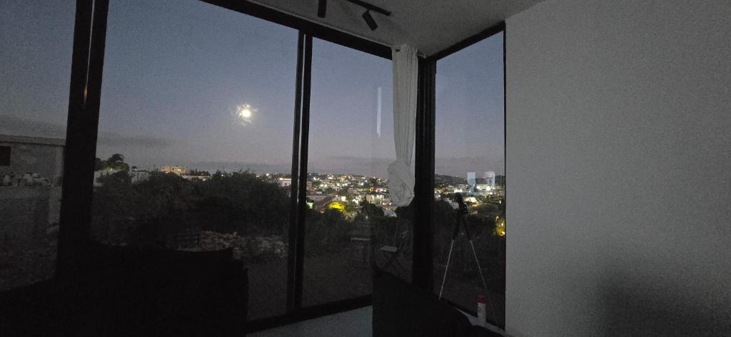 een kamer met een raam met uitzicht op de stad bij Goshen in ‘Isfiyā