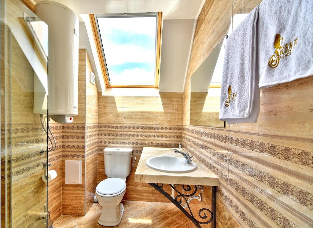 a bathroom with a toilet and a sink at Sirena Palace Family Hotel in Obzor