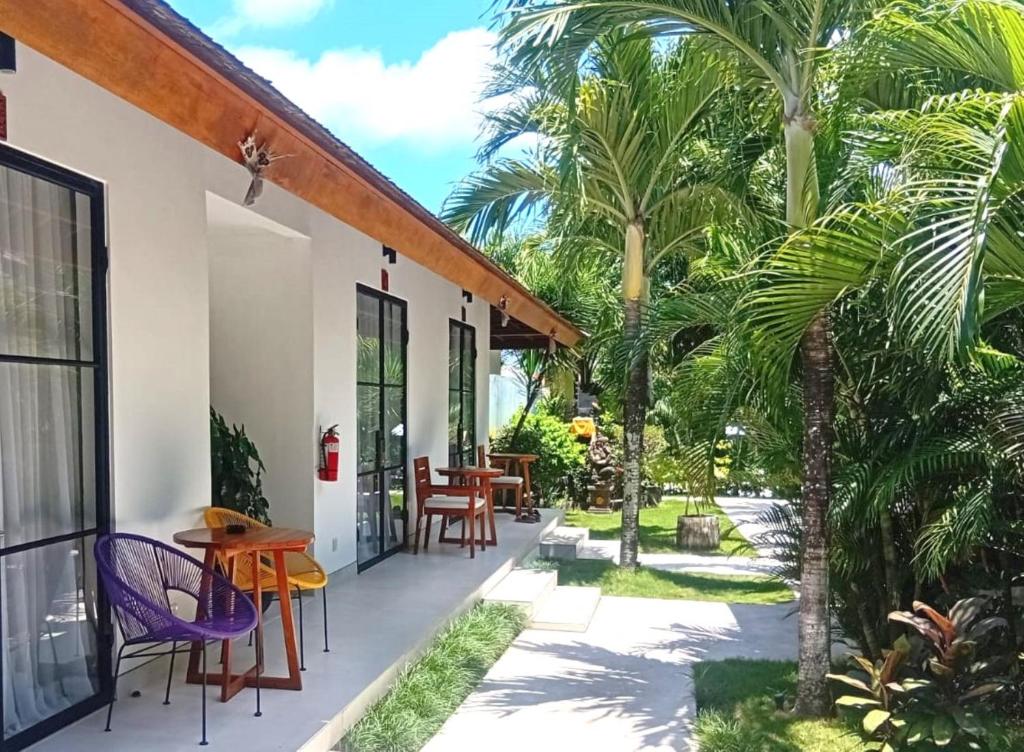 a patio with palm trees and a table and chairs at Nature's Immersion Room at Anwa Bali Boutique Resort in Canggu