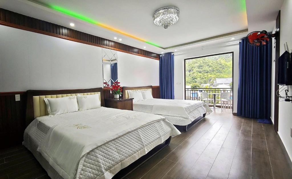 a bedroom with two beds and a rainbow on the wall at Hana Homestay KGR in Xuan Dam